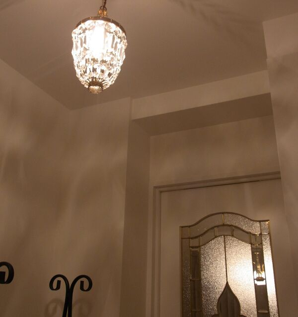 玄関ホールの照明の一例：ミニシャンデリアを主照明に据えた、おしゃれな玄関の施工実例