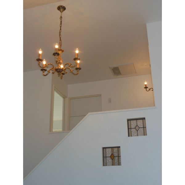 階段ホールに、真鍮製でトラディショナルな照明器具を設置した施工写真
