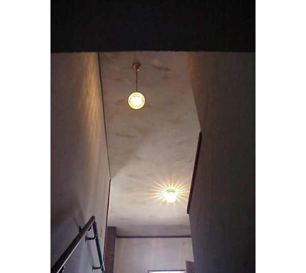 階段下から見上げたペンダントライト。奥には2階ホールの照明器具も見えます
