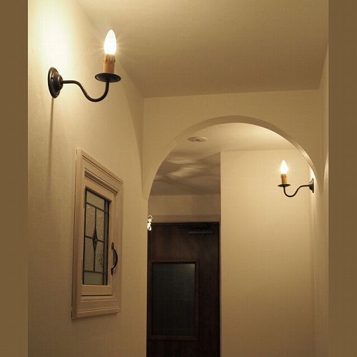 おしゃれな廊下・ホールのおすすめ照明―R垂れ壁やステンドグラス窓の装飾がおしゃれな廊下に設置したキャンドル型ブラケットライトWB801/Z