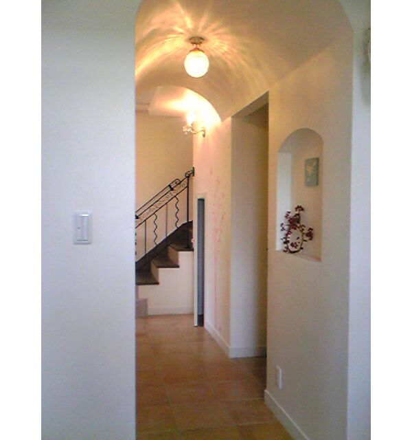 白壁とアーチ天井が特徴的な廊下。シーリングライトからの光が美しい曲線を描いています。