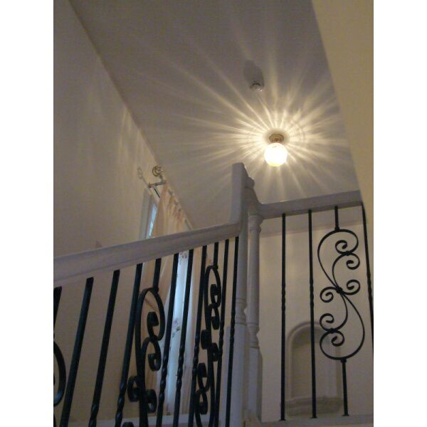 階段を上がりきったホールの天井に、光の模様が美しいアンティーク調の天井灯