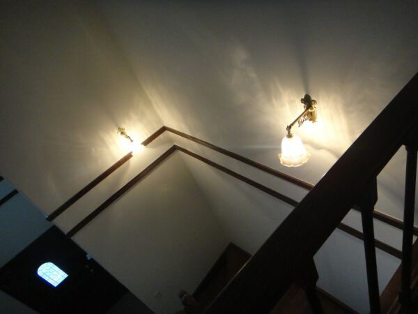シックで落ち着いた雰囲気の階段に灯る、アンティーク風のおしゃれな壁照明