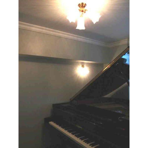 グランドピアノの入った部屋にとてもトラディショナルな天井灯とブラケットライト