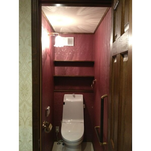 赤い壁がクラシカルでおしゃれなトイレに、アンティーク調のブラケットライト