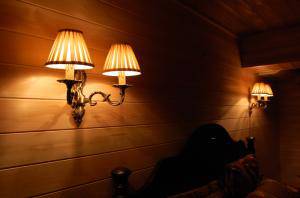 ログハウスのベッドルーム照明として使われた布シェードつきのブラケットライト2台