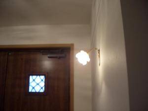バラの形のガラスシェードをもつブラケットライトを玄関の照明用に設置―おしゃれな照明実例