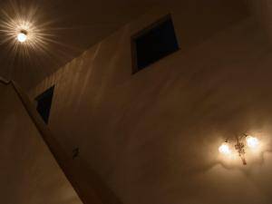 同じトーンの光を出す照明が、階段の上と下にあります―おしゃれなアンティーク風照明の施工例