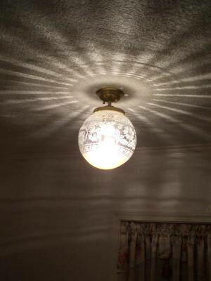 玄関ホールの天井に綺麗な光の模様を映し出すアンティーク調の照明