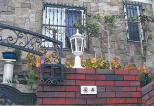 色鮮やかなレンガ造りの門の上に、おしゃれな外灯EP022/Wを設置
