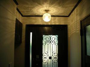 玄関ドアの装飾、ホールの内装、そしてシーリングライトの光がすべて調和した美しい玄関―アンティーク風照明のおしゃれな実例