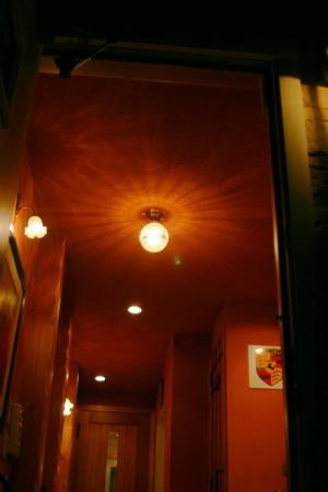 おしゃれな赤い玄関にコーディネートされた天井灯と壁つけ灯