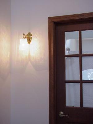 リビングに続くドア横の壁に設置された廊下のブラケットライト―おしゃれな照明施工例